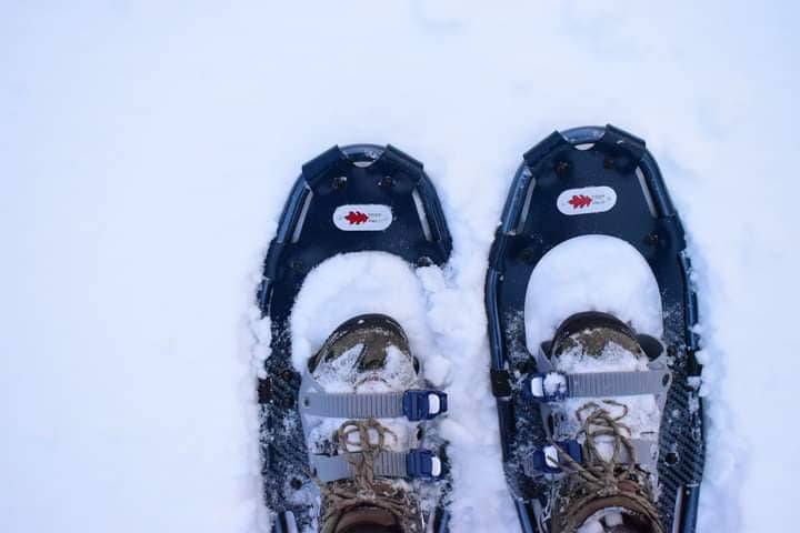 close up of a pair of boots in snowshoes in the snow